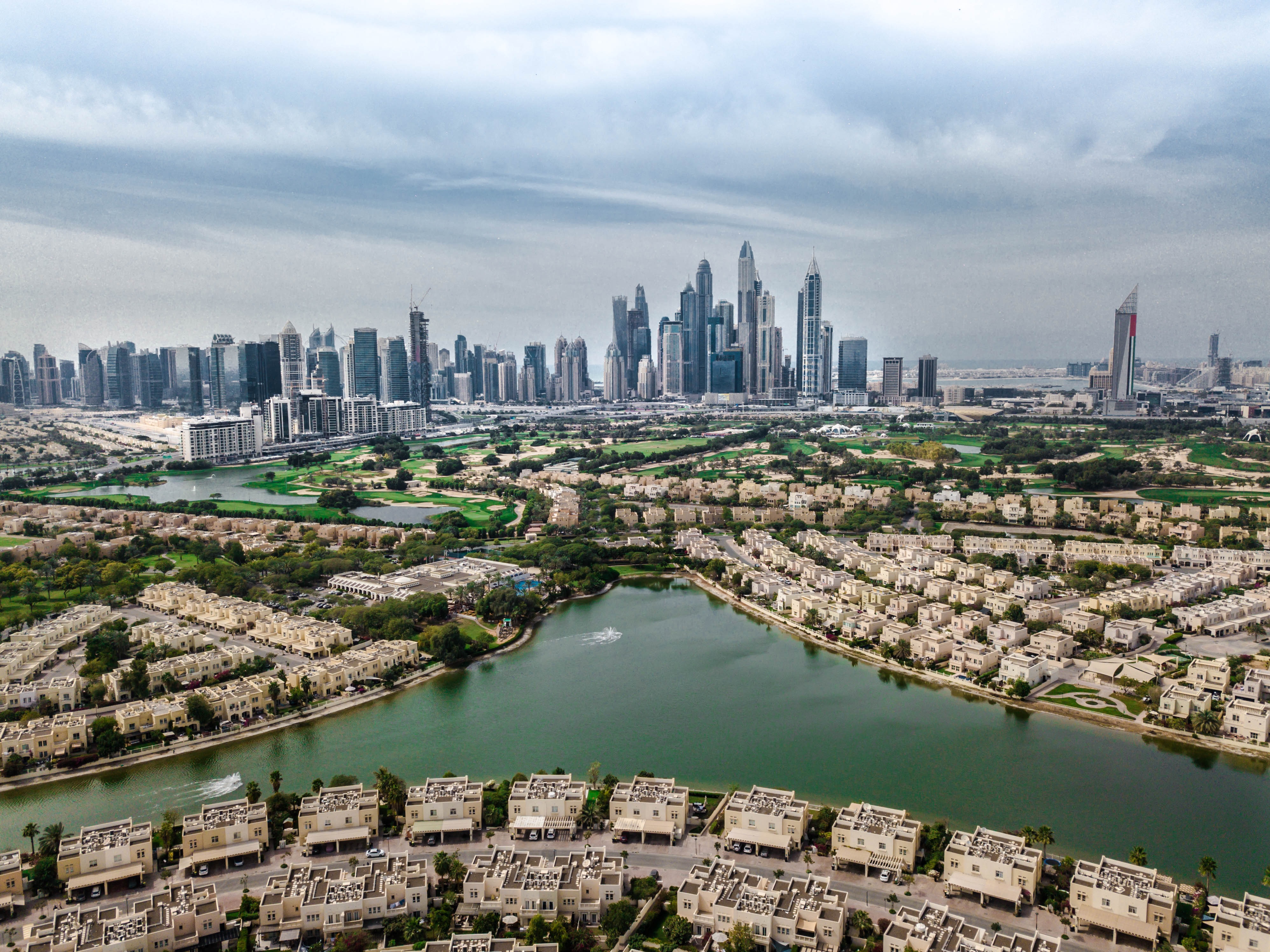 Emirates Hills_a city with many tall buildings and a river