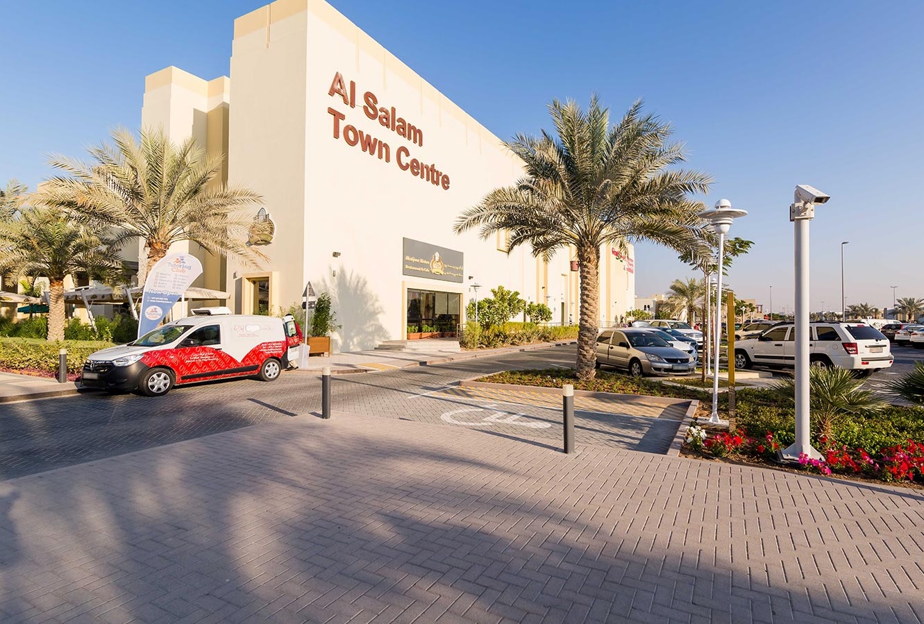 Mudon_a white car parked in front of a large building